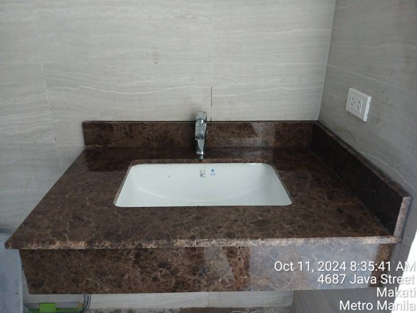 Rectangular sink with a brown marble countertop, chrome faucet, and wall outlet above the counter. Date, time, and location details are overlaid on the bottom right of the image.
